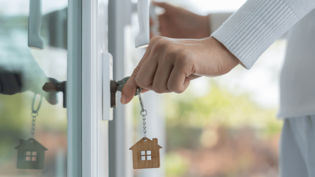 a person holding a key with a house on it