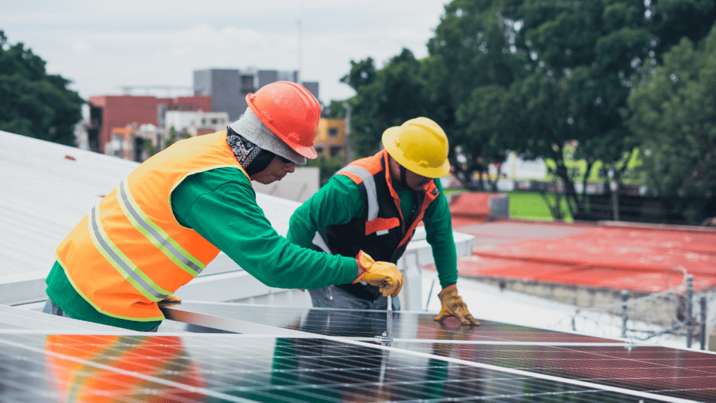 Two people working on a solar panel on a roof