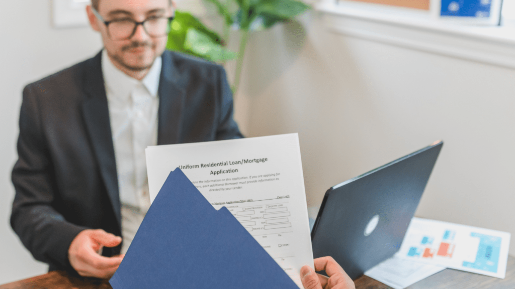 a person in a suit is sitting at a desk and holding a piece of paper