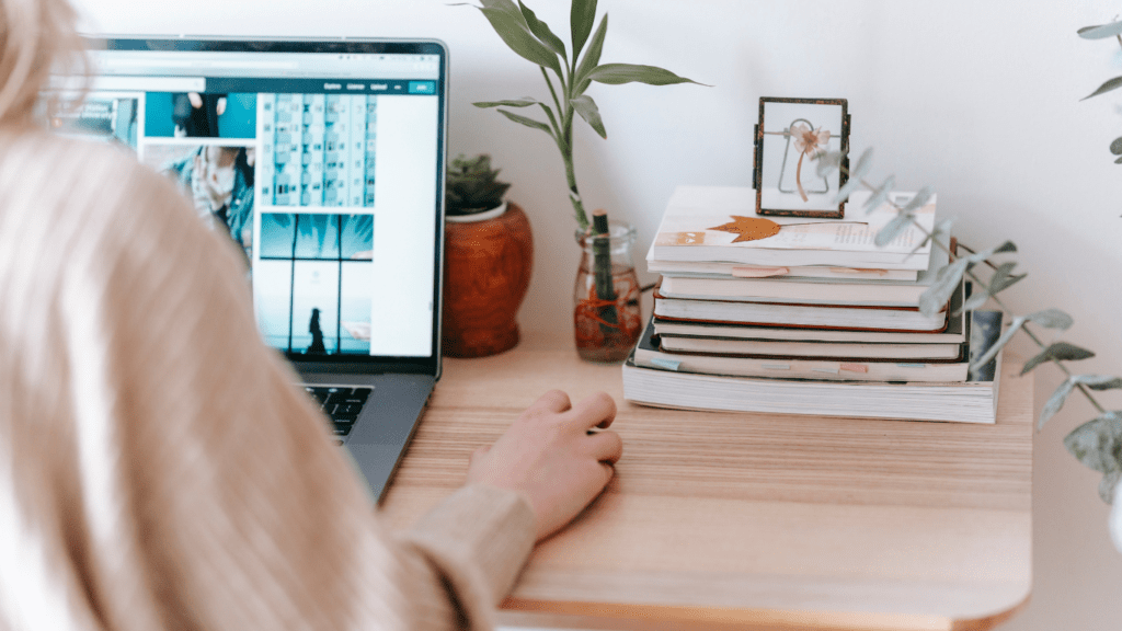 A person sitting at a desk with a laptop and books