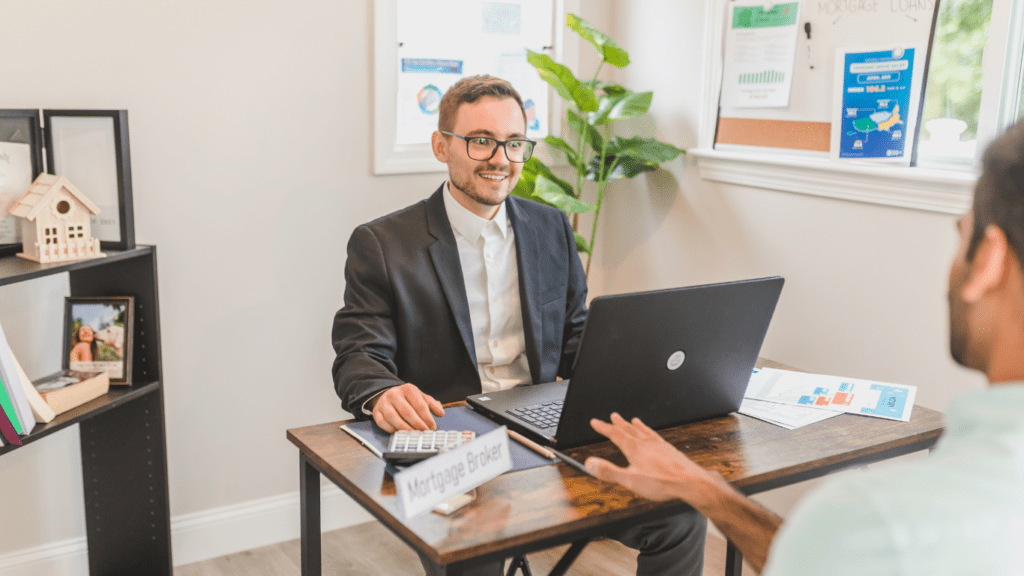 a person in a suit sitting at a desk with a laptop