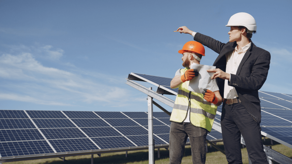 Two people working on a solar panel on a roof