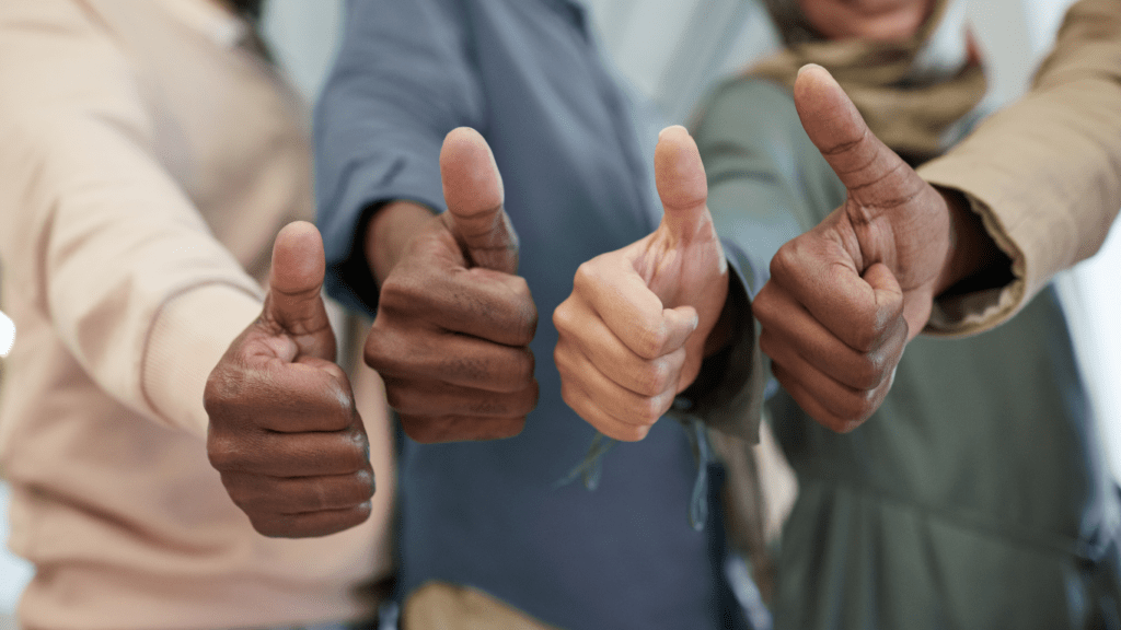 a group of people showing thumbs up in front of each other