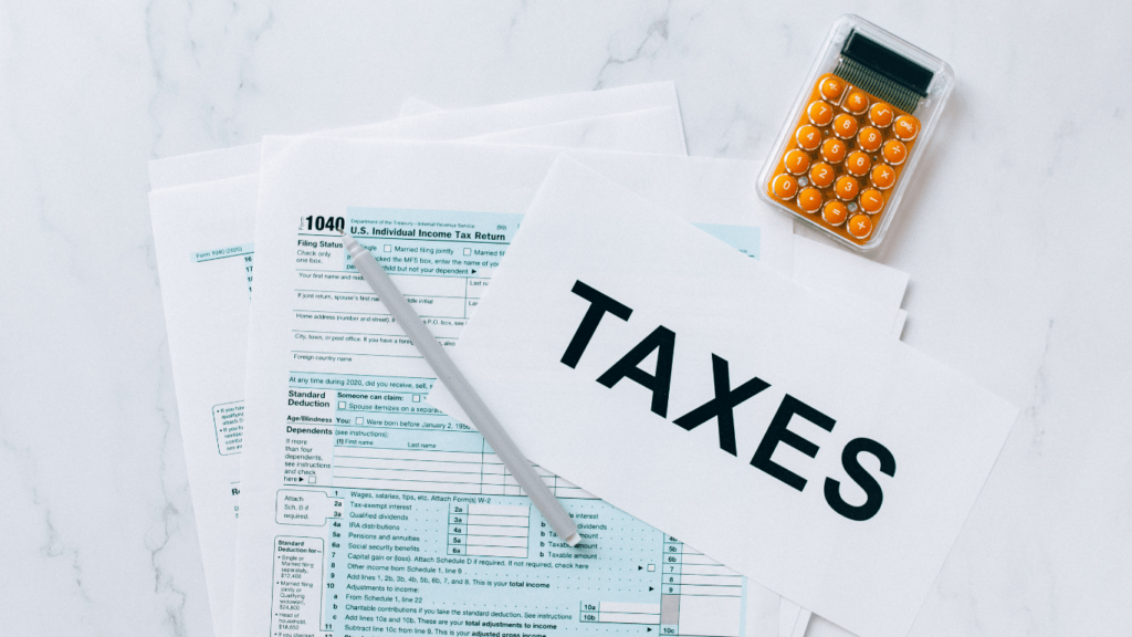 taxes and calculator on a white marble surface