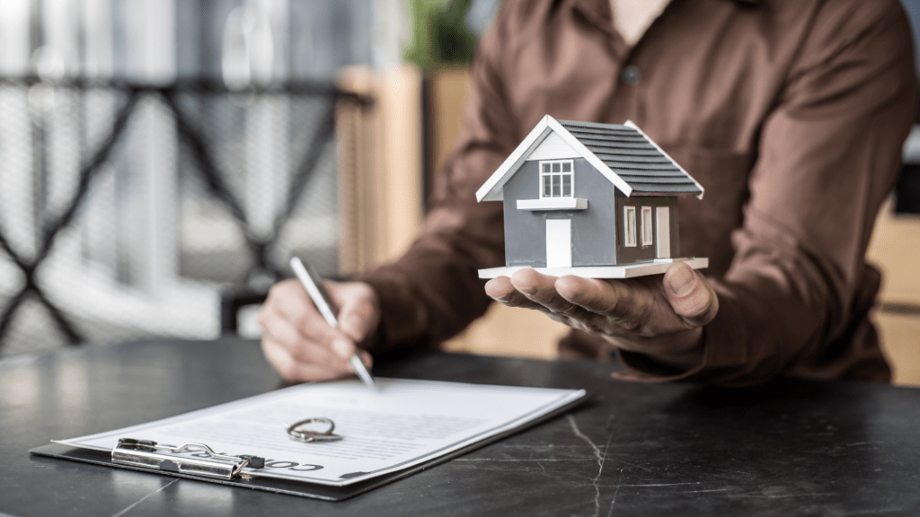 a real estate agent holding a model of a house