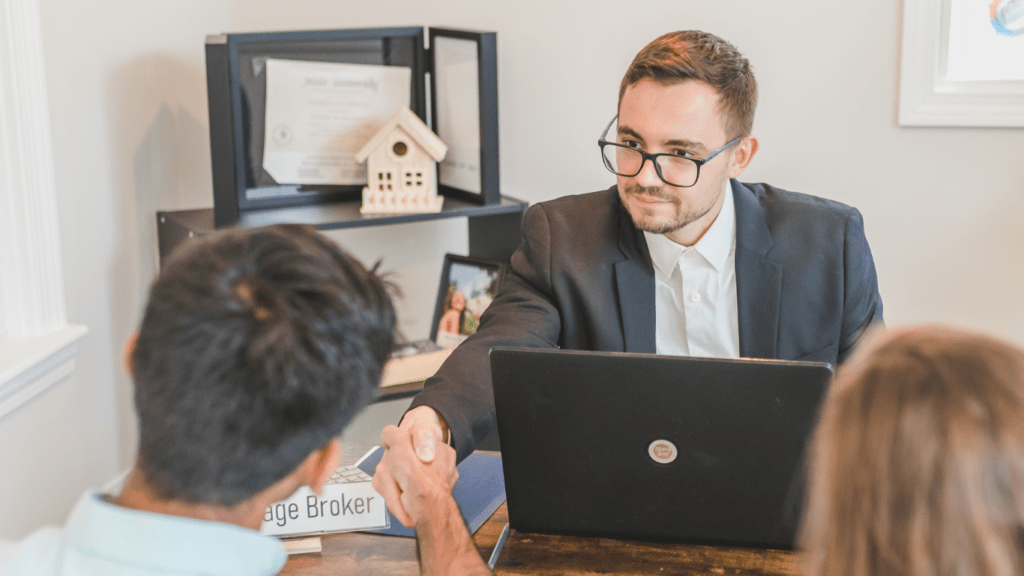 a person in a suit sitting at a desk with a laptop