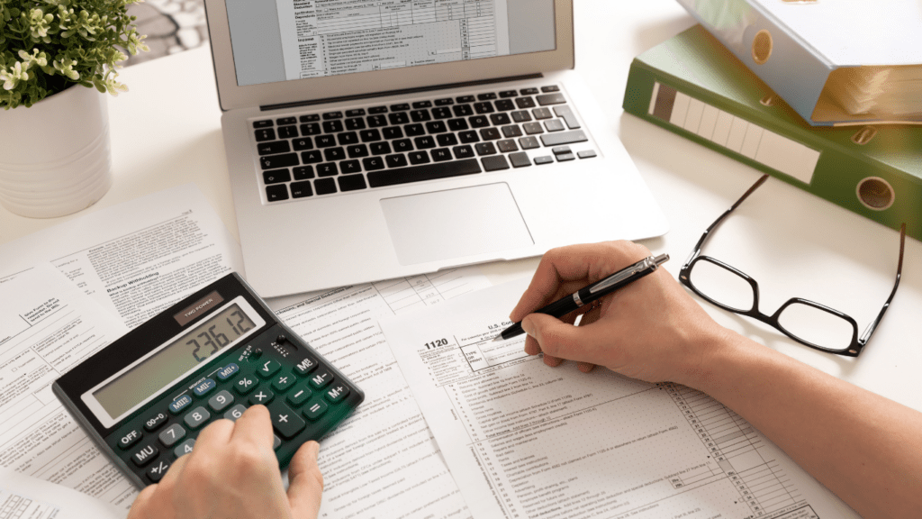 a person is using a calculator while sitting at a desk