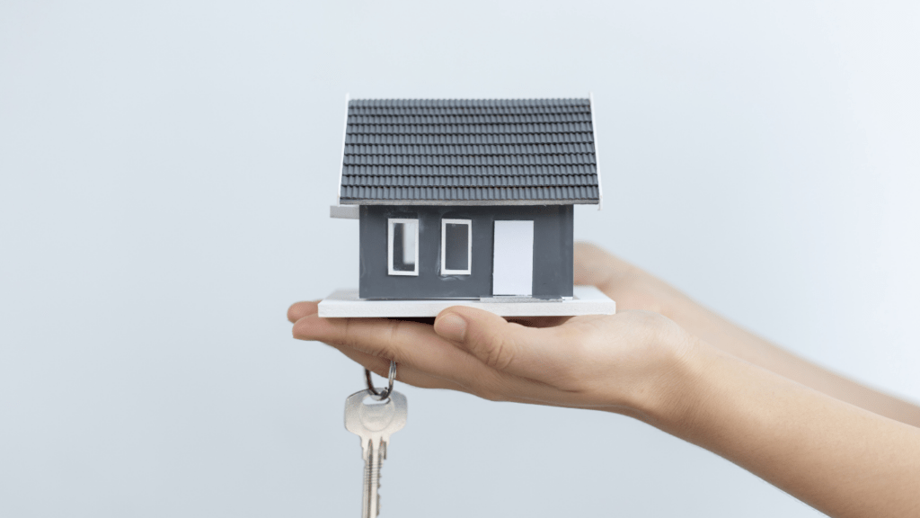 a real estate agent holding a model of a house