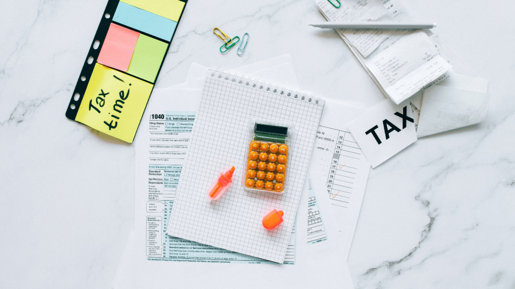 taxes and calculator on a white marble surface