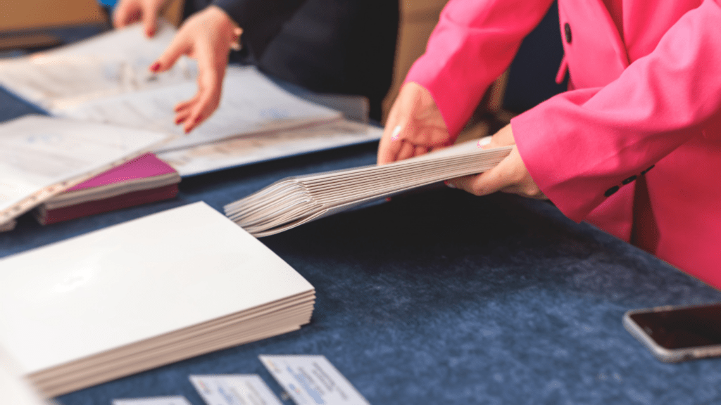 two individuals in business attire looking at papers on a table