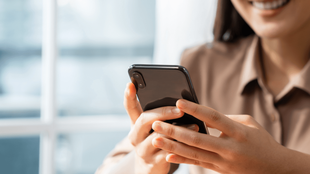 Smiling young woman holding a smartphone