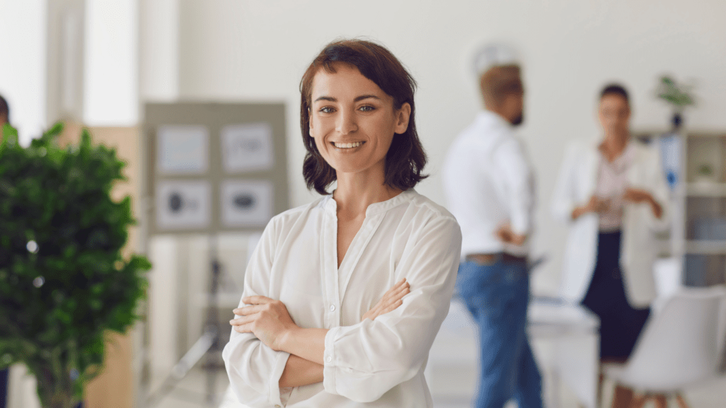 Happy successful business lady standing in office