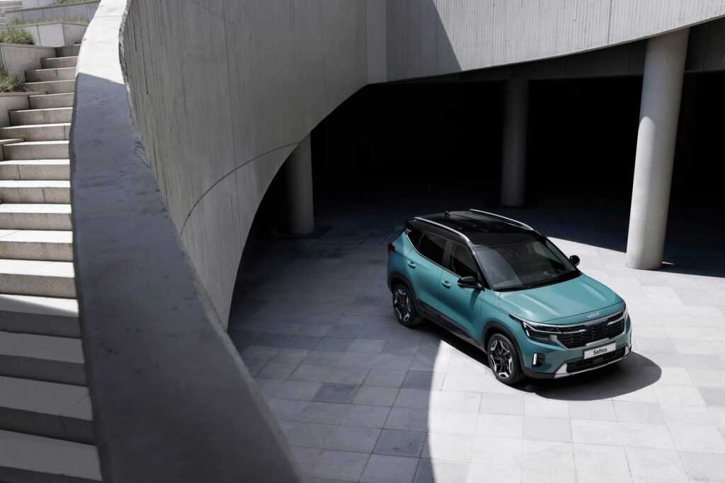 Green SUV parked in a modern architectural setting with concrete walls and stairs.